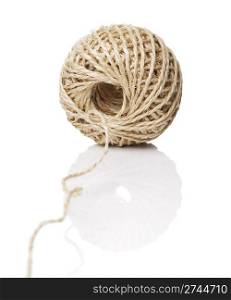 A Roll of natural fiber string on reflective background.