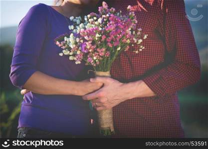 a romantic couple holding Valentines gift and flowers, vintage tone.
