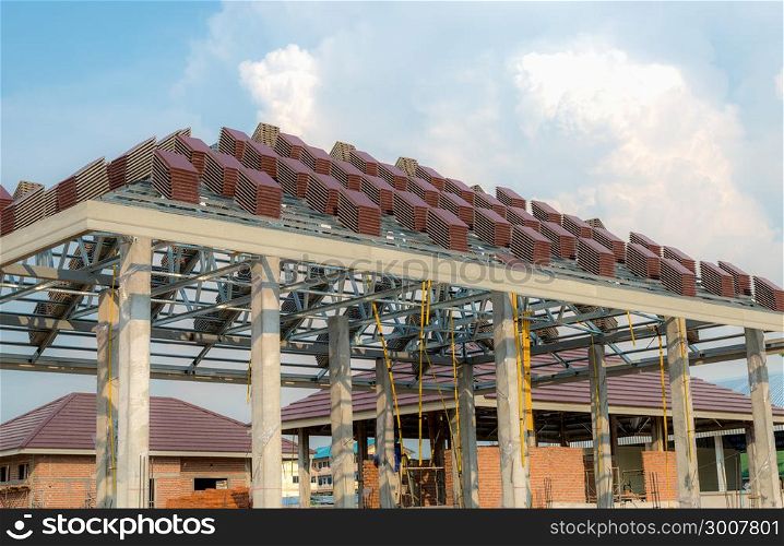 A roof under construction with stacks of roof tiles for home building