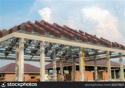 A roof under construction with stacks of roof tiles for home building