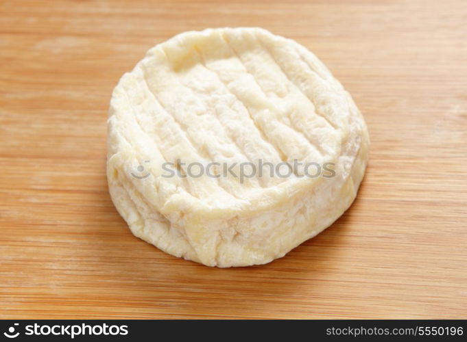 A round of Saint-Marcellin French cheese on a cheeseboard. The ultra-soft cow&rsquo;s milk cheese becomes increasingly runny as it ages and has a strong aroma.