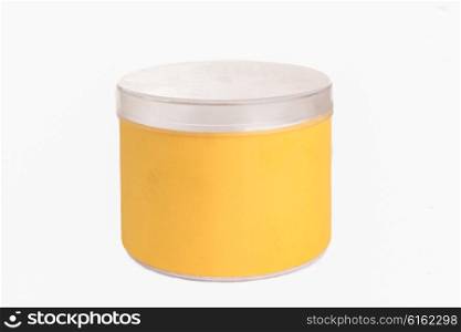 A round yellow plastic container with a silver cap on a white background.