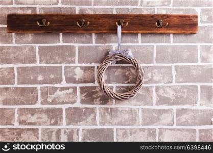 A row of hooks for clothes on the brick wall. The cloth hanger