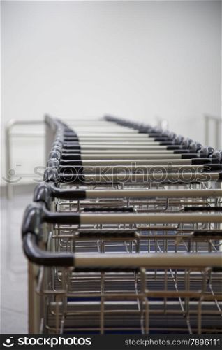 A row of luggage carts at the departure hall in the airport