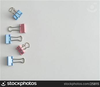 A row of pink and blue binder clips