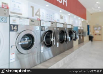 A row of qualified coin-operated washing machines in a public store. Concept of a self service commercial laundry and drying machine in a public room.. A row of qualified coin-operated washing machines in a public store.