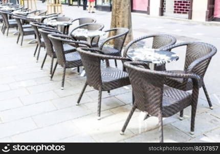 A row of small tables of a cafe on a pedestrian street