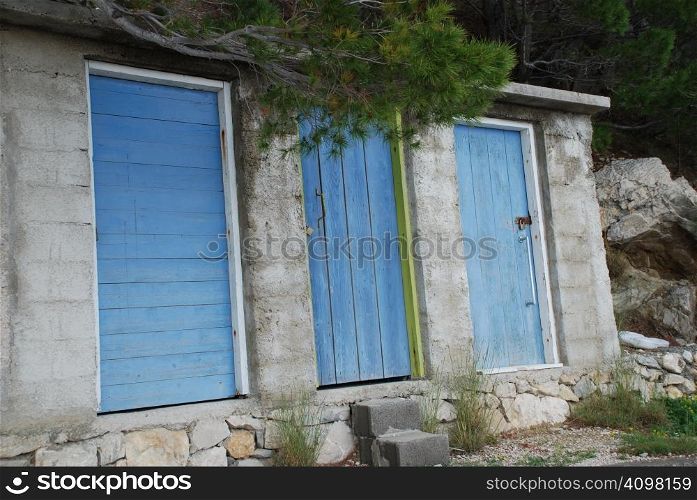 A row of three, blue doored public toilets on the seafront at Brela, on the Adriatic coastline of Croatia