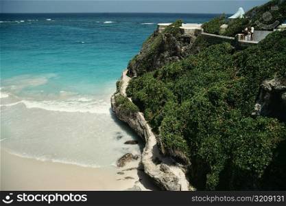 A rugged rock formation is seen next to a beach at Barbados coast, Caribbean