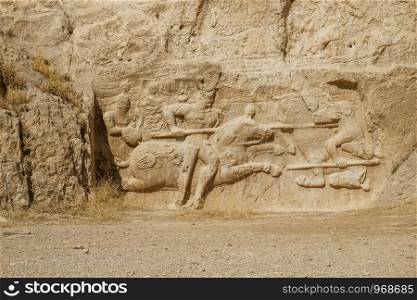 A ruin and ancient Sassanid rock relief depiction of the equestrian relief of Hormizd II, Naqsh-e Rostam, Fars Province. Shiraz, Iran.