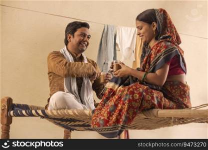 A RURAL COUPLE SITTING TOGETHER AND DRINKING TEA