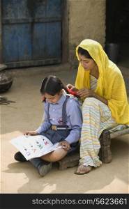A rural mother sitting with her daughter