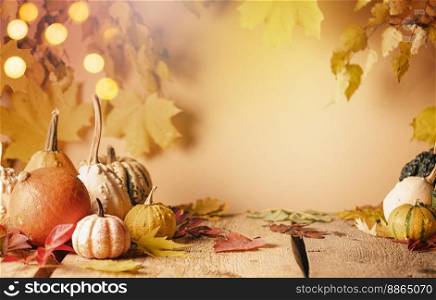 A rustic autumn still life with pumpkins and golden leaves on a wooden surface. Concept of Thanksgiving day or Halloween with copy space. A rustic autumn still life