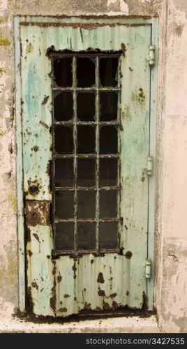 A rusty door at the old Alcatraz maximum security prison in San Francisco. This door, once painted green, has rusted out over the years due to a lack of maintenance and is now a symbol of neglect.