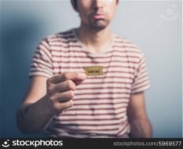 A sad and lonely man is holding a cinema ticket