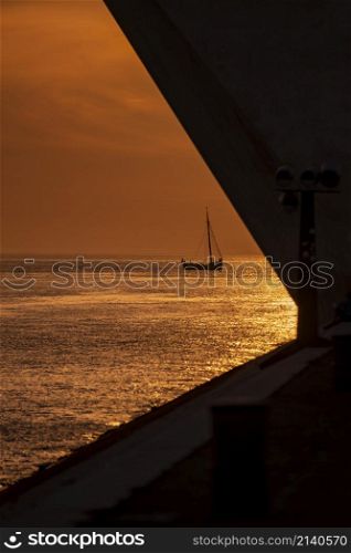 a sailboat at sunset at the monument of Discoveries or Pedaro dos Descobrimentos in Belem near the City of Lisbon in Portugal. Portugal, Lisbon, October, 2021