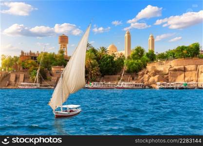 A Sailboat in The Nile near the Coptic Orthodox Cathedral of the Archangel Michael, Aswan, Egypt.. A Sailboat in The Nile near the Coptic Orthodox Cathedral of the Archangel Michael, Aswan, Egypt