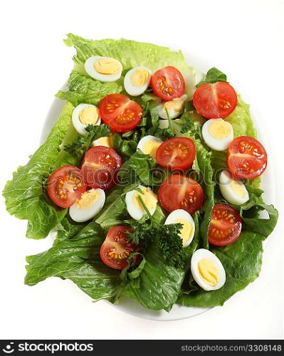 A salad of quail&acute;s eggs, cherry tomatoes, lettuce and parsley