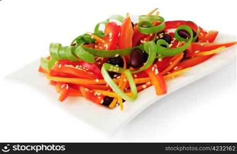 A salad of tomatoes, sweet peppers, red beans, carrots with sesame
