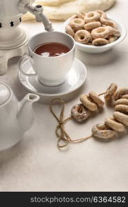 a samovar with bagels and hot tea on the white tablecloth