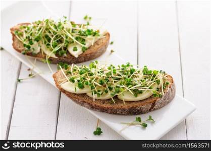a sandwich with green young sprouts, micro greens and mozzarella, a healthy and healthy snack