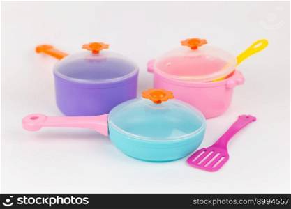 a saucepan frying pan and appliances childish plastic toys on a white background. saucepan frying pan and appliances childish plastic toys on a white background