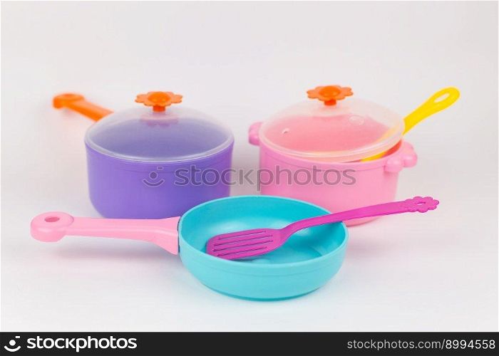 a saucepan frying pan and appliances childish plastic toys on a white background. saucepan frying pan and appliances childish plastic toys on a white background