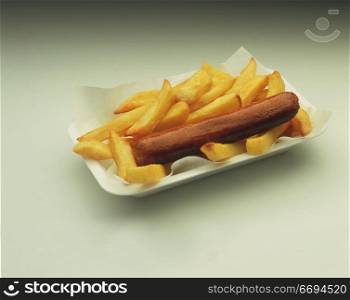 a sausage with fries in a takeaway tray