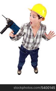 A scared female construction worker with a drill.