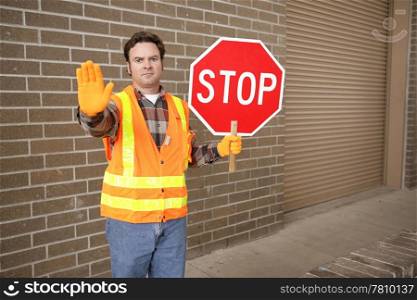 A school crossing guard holding a stop sign. Room for text.