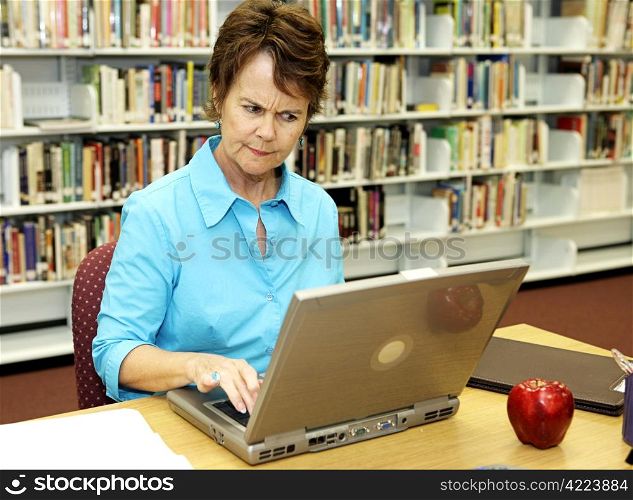 A school librarian frowns as she reviews students online activity.