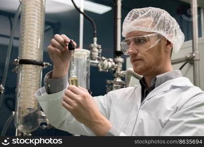 A scientist or apothecary extracts CBD hemp oil for medicinal purposes in a laboratory. Alternative cannabis-based medicine produced from cannabis extraction machine.. Scientist or apothecary extract CBD hemp oil for medicinal purpose in laboratory