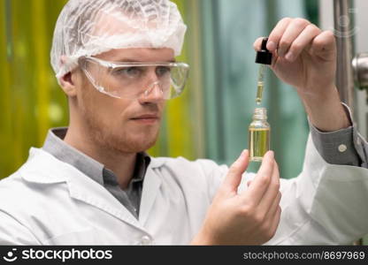 A scientist or apothecary extracts CBD hemp oil for medicinal purposes in a laboratory. Alternative cannabis-based medicine produced from cannabis extraction machine.. Scientist or apothecary extract CBD hemp oil for medicinal purpose in laboratory