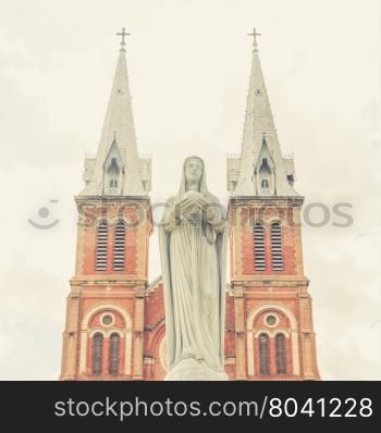 A sculpture of the Virgin Mary in front of the Notre-Dame Saigon Basilica in Ho Chi Minh City, Vietnam (Vintage filter effect used)