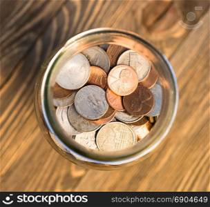 A selection of coins contained in a glass jar