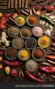 A selection of various colorful spices on a wooden table in bowl. Wooden table of colorful spices