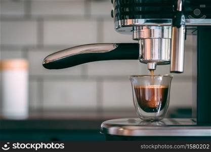 A selective focus shot of an espresso machine making tasty warm coffee in the morning. Selective focus shot of an espresso machine making tasty warm coffee in the morning