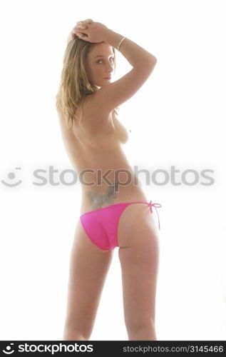 A semi-nude image of a young model wearing pink bikini bottoms.