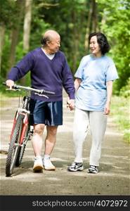 A senior active asian couple walking and exercise at the park