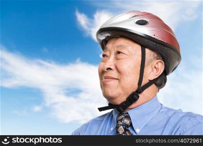 A senior asian businessman wearing a bike helmet outdoor