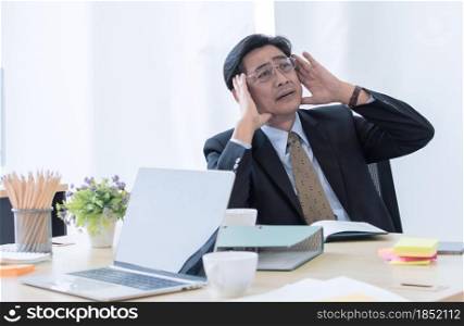 A senior asian man worry and stress about annual report of the business