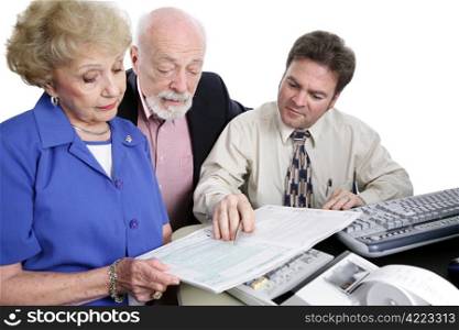 A senior couple going over the tax booklet with their accountant. Isolated on white.