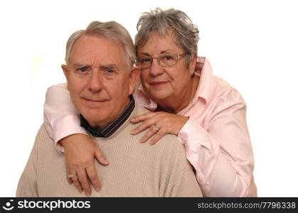 A senior couple in a closeup shot hugging for a portrait, on whitebackground.