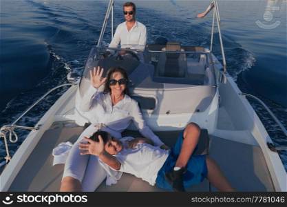 A senior couple in casual outfits with their son enjoy while riding a boat at sea at sunset. The concept of a happy family. Selective focus. High-quality photo. A senior couple in casual outfits with their son enjoy while riding a boat at sea at sunset. The concept of a happy family. Selective focus 