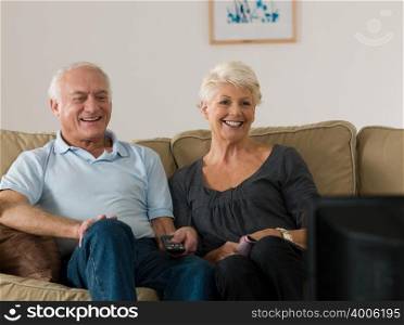 A senior couple watching tv
