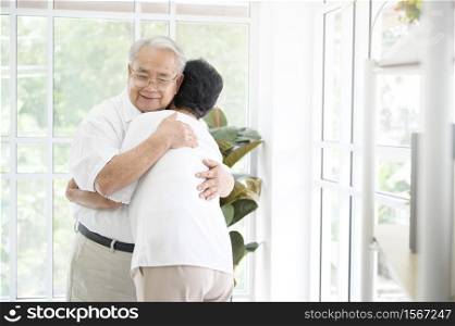 A senior elderly couple are hugging in home, together , family concept .. A senior elderly couple are hugging in home