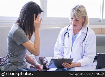 A senior female caucasian doctor giving consultation and advice to a patient at the hospital. Medical and Insurance Concept.