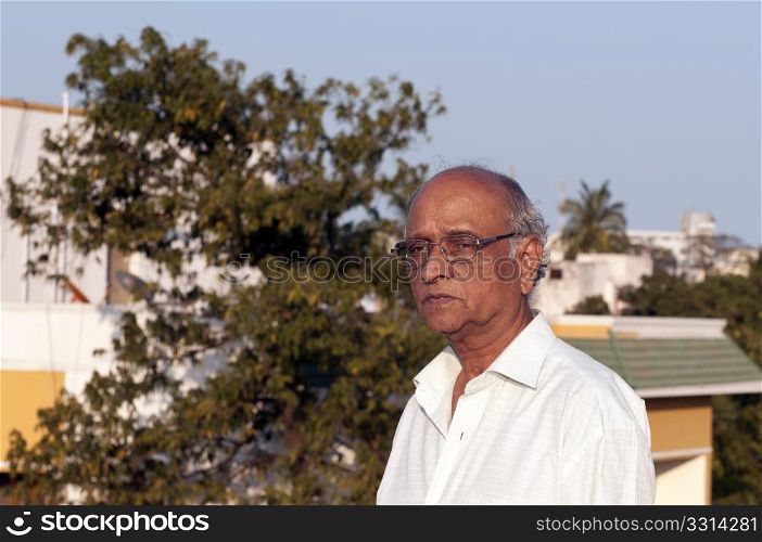 A senior Indian man looking very sad