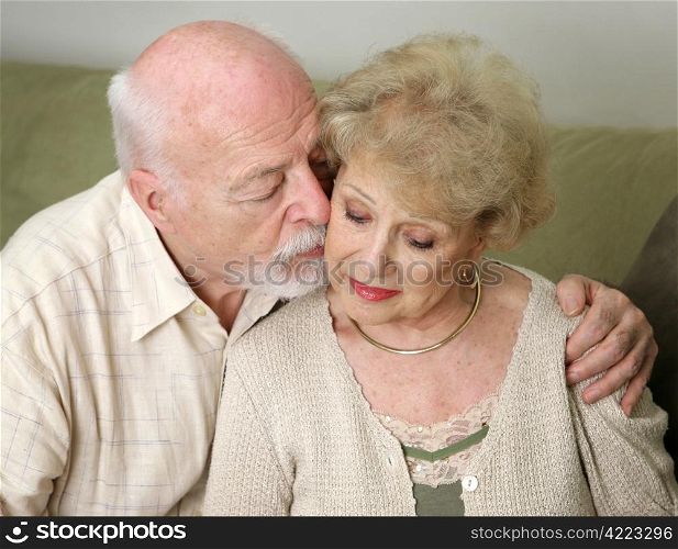 A senior man and wife deeply in love. She is upset and he is comforting her.