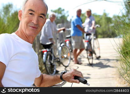 a senior man doing bike with friends in summer